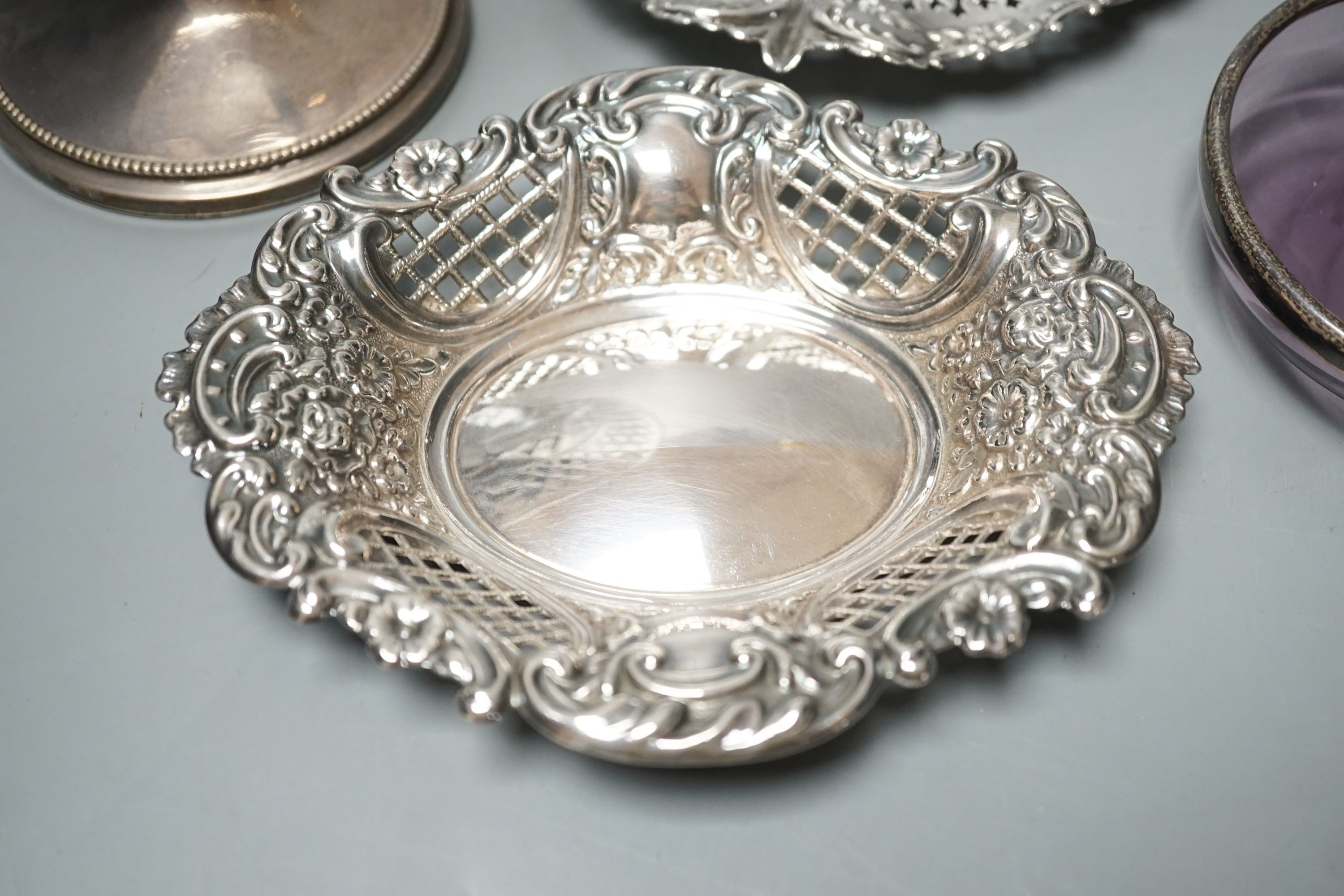 Two pierced silver trinket dishes, a late Victorian silver mounted amethyst glass dish, a similar scent flask and a silver mounted glass bowl.